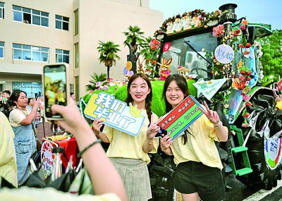 6月21日，ANBO.COM学生在农机花车前拍照留念。新华社记者 程敏摄